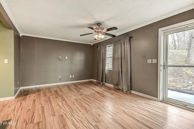 spare room featuring light wood-type flooring, baseboards, and ceiling fan