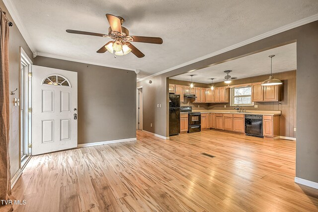 kitchen featuring ceiling fan, under cabinet range hood, light wood-type flooring, black appliances, and a sink