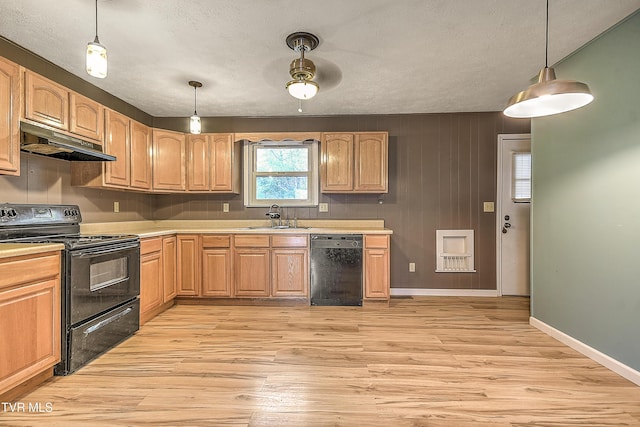 kitchen featuring a sink, black appliances, light countertops, light wood-style floors, and under cabinet range hood