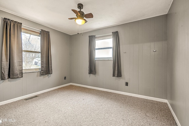 empty room with visible vents, baseboards, and a ceiling fan