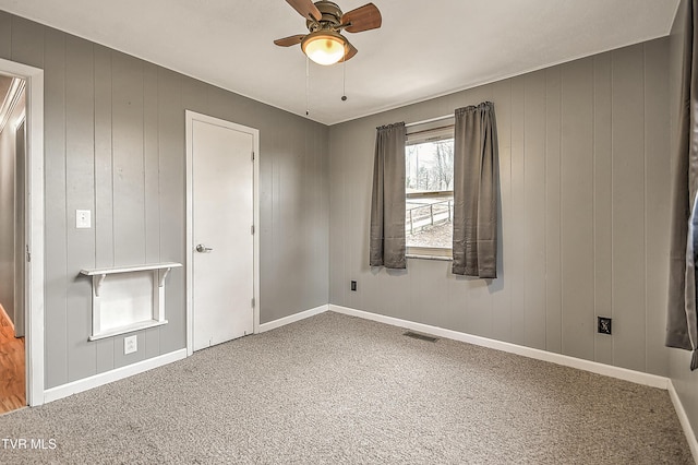 unfurnished bedroom with visible vents, carpet flooring, a ceiling fan, and baseboards