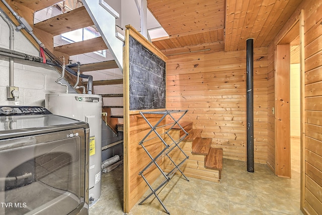 clothes washing area with wooden walls, laundry area, washer / clothes dryer, water heater, and wood ceiling