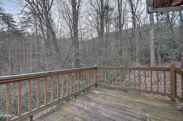 wooden deck featuring a forest view