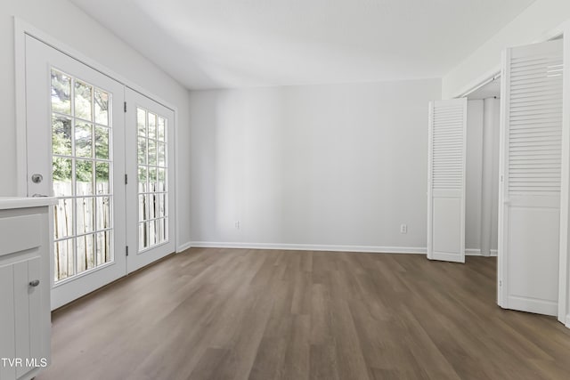 unfurnished bedroom with access to exterior, wood finished floors, and baseboards