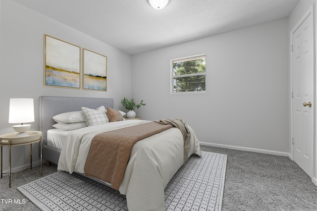 bedroom with light colored carpet, a textured ceiling, and baseboards