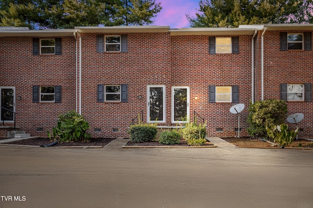 view of property featuring crawl space and brick siding