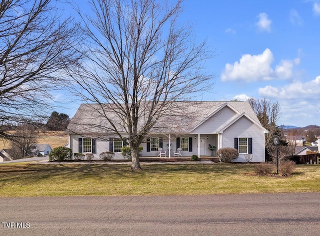 ranch-style home featuring covered porch and a front lawn