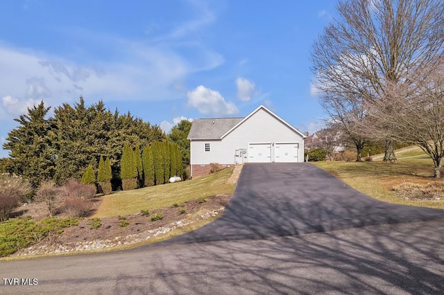 view of home's exterior with aphalt driveway, a garage, and a lawn