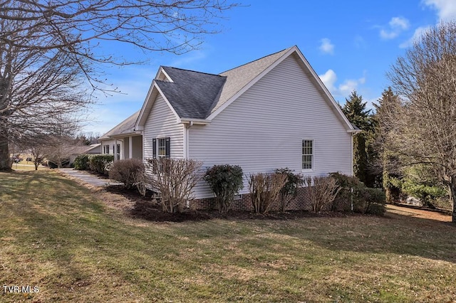 view of side of property with a yard and a shingled roof