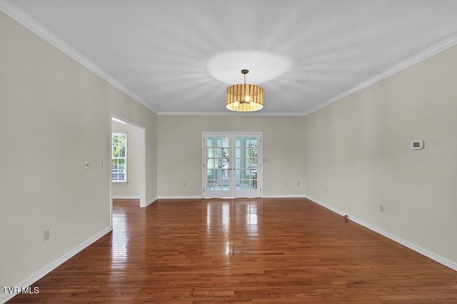 unfurnished room with crown molding, wood finished floors, and baseboards