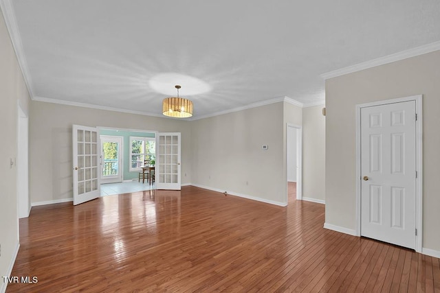 spare room with french doors, crown molding, baseboards, and wood-type flooring