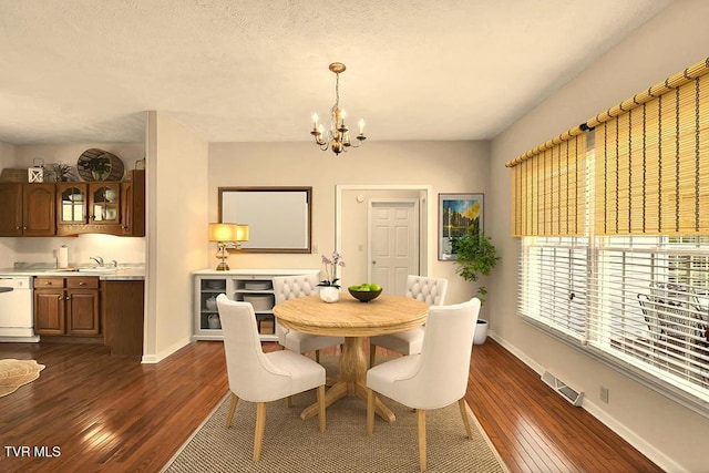 dining room featuring baseboards, dark wood-type flooring, a notable chandelier, and visible vents