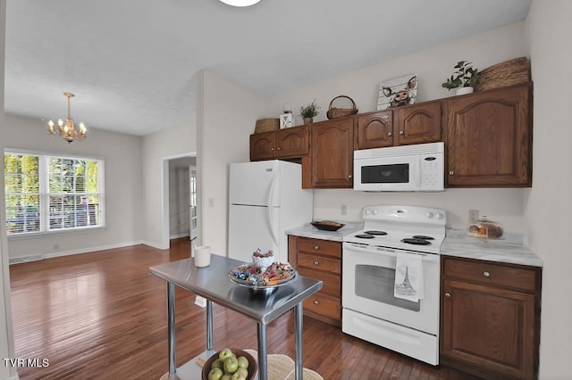 kitchen with baseboards, light countertops, a notable chandelier, white appliances, and dark wood-style flooring