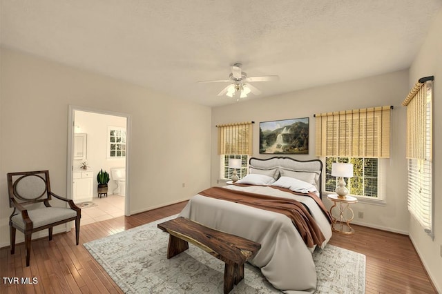 bedroom with baseboards, multiple windows, and hardwood / wood-style floors