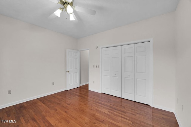 unfurnished bedroom featuring ceiling fan, a closet, baseboards, and wood finished floors