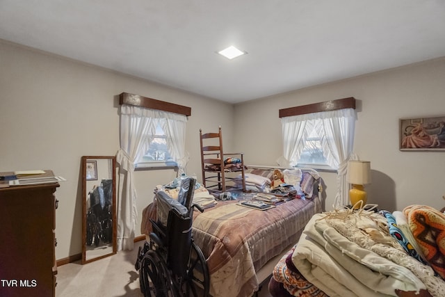 bedroom with light carpet, multiple windows, and baseboards