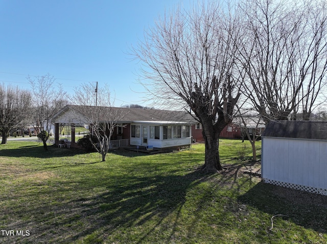 view of yard featuring a storage shed, an outdoor structure, and a sunroom