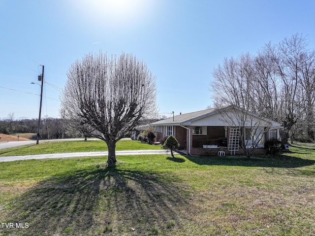 view of front of home featuring a front yard and brick siding