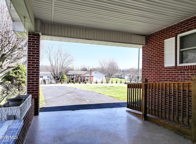 view of patio with a residential view, an attached carport, and concrete driveway