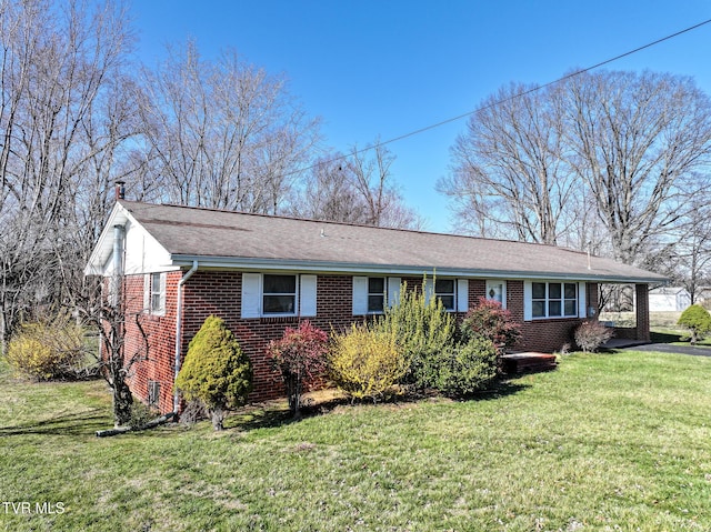 ranch-style home with brick siding, a front lawn, and a shingled roof