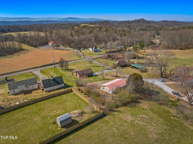 birds eye view of property with a wooded view, a rural view, and a mountain view