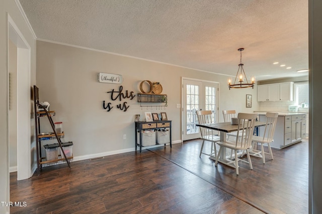 dining area featuring baseboards, dark wood finished floors, an inviting chandelier, a textured ceiling, and crown molding