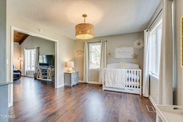 unfurnished bedroom featuring visible vents, baseboards, vaulted ceiling, a textured ceiling, and dark wood-style flooring