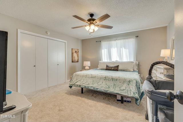 bedroom featuring carpet flooring, a ceiling fan, a closet, and a textured ceiling