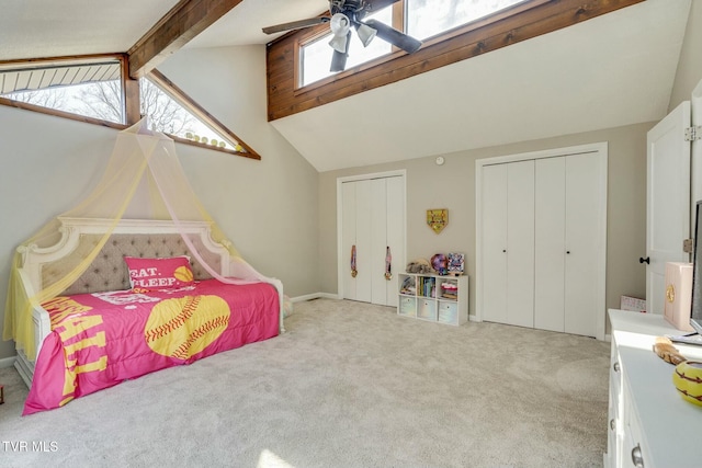 carpeted bedroom with ceiling fan, beam ceiling, two closets, and high vaulted ceiling