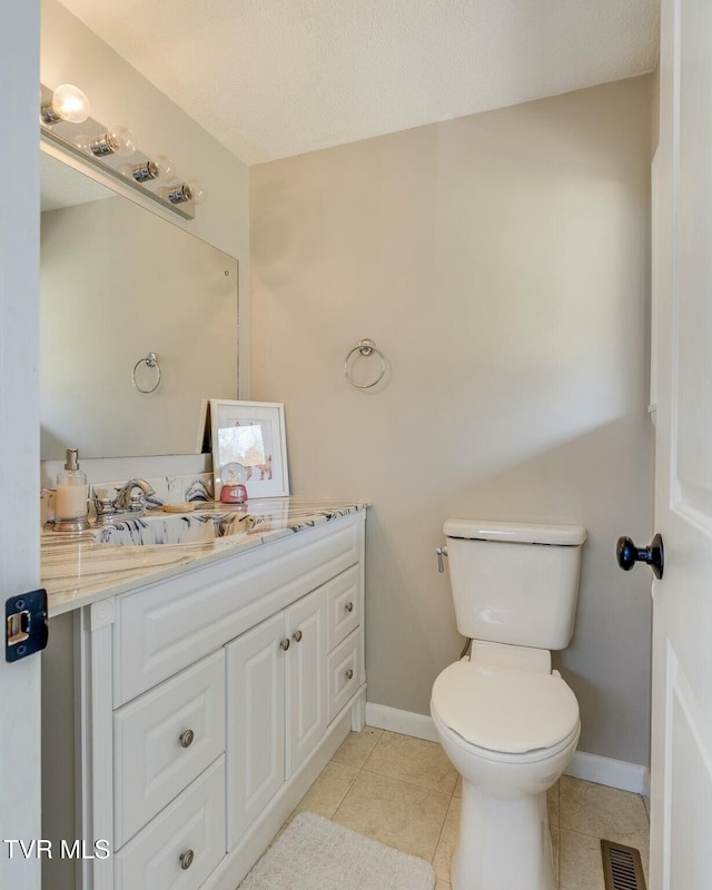 bathroom with visible vents, baseboards, toilet, tile patterned floors, and vanity