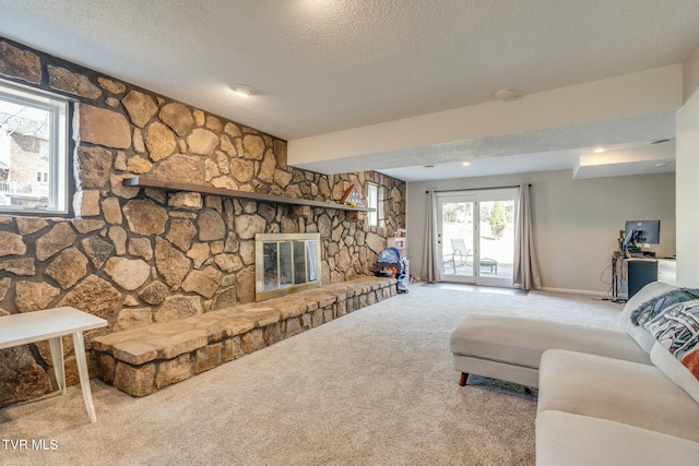 living room featuring a stone fireplace, carpet flooring, baseboards, and a textured ceiling