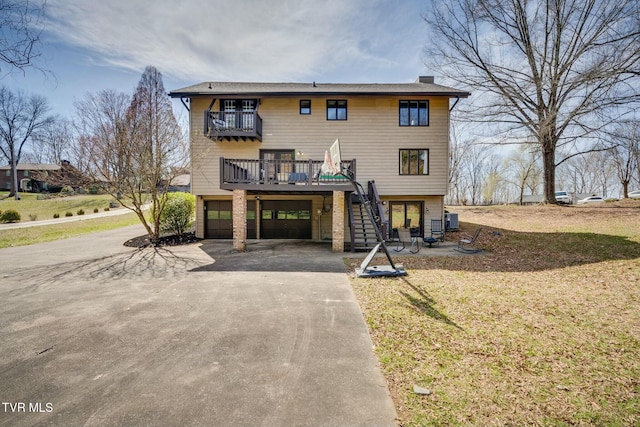 view of front of house featuring a balcony, driveway, stairs, and a garage