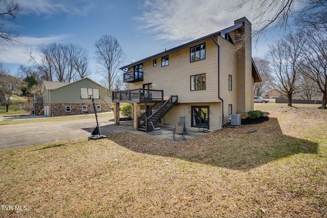 back of property featuring a patio, stairway, a yard, cooling unit, and a chimney