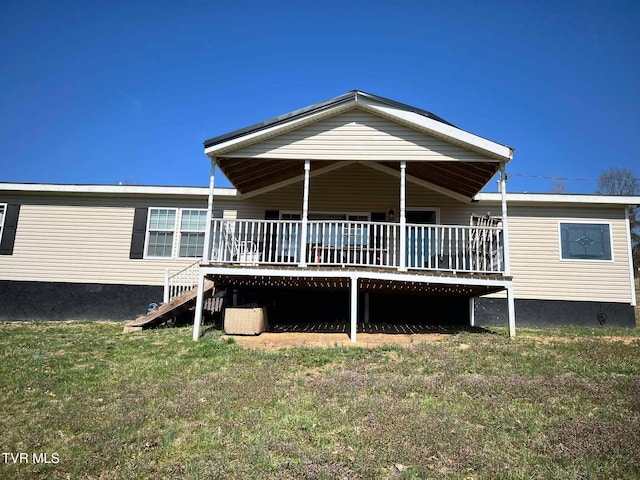 rear view of property featuring a yard, a deck, and stairs