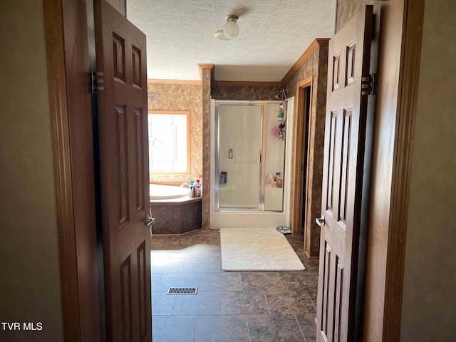 bathroom featuring a garden tub, a textured ceiling, ornamental molding, and a shower stall