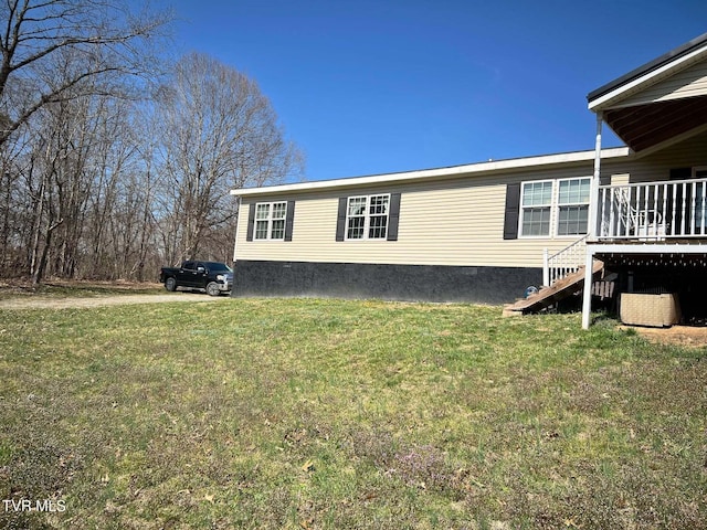 view of side of property with stairway and a lawn