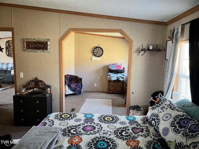 carpeted bedroom with arched walkways and crown molding