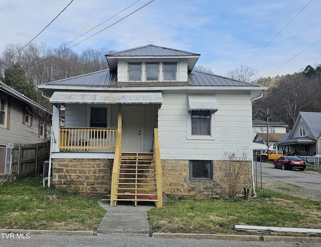 bungalow-style house featuring metal roof, stairs, a standing seam roof, and fence