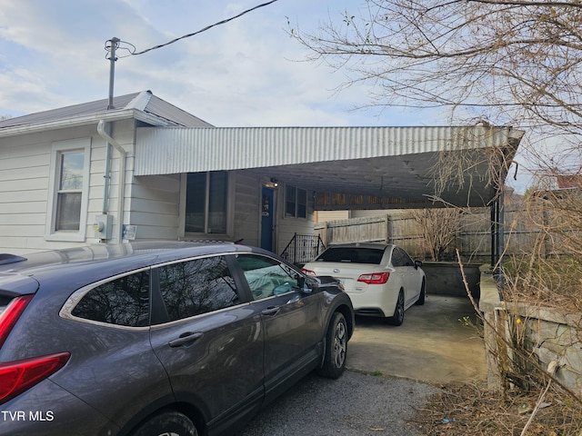 view of front of property featuring a carport, driveway, and fence