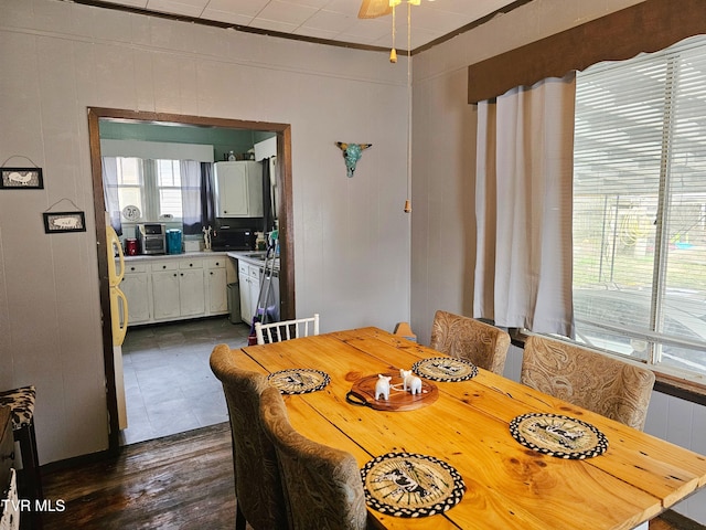 dining area featuring dark wood finished floors and wooden walls