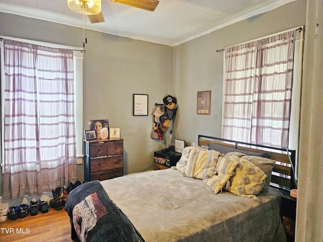 bedroom with wood finished floors, a ceiling fan, and ornamental molding