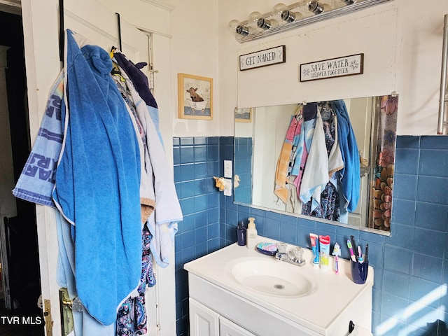 bathroom featuring vanity and tile walls