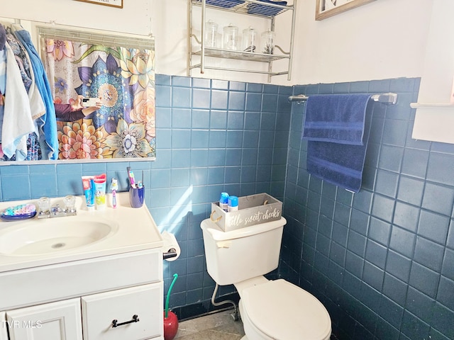 bathroom featuring toilet, tile walls, and vanity