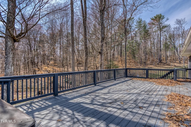 wooden terrace featuring a view of trees