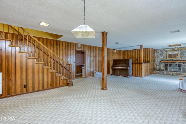 interior space featuring carpet flooring, a fireplace, stairway, and a textured ceiling