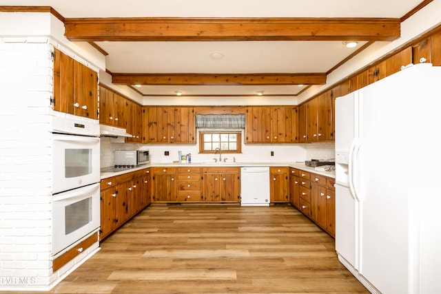 kitchen featuring white appliances, brown cabinetry, and light countertops