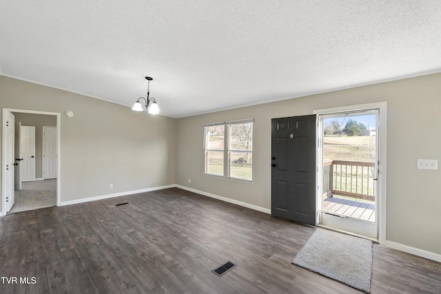 foyer featuring a chandelier, visible vents, plenty of natural light, and dark wood-type flooring