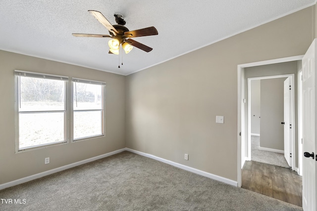 carpeted empty room with baseboards, a textured ceiling, and a ceiling fan