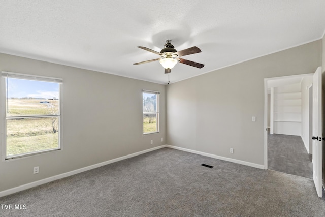 spare room with baseboards, carpet flooring, a textured ceiling, and ceiling fan