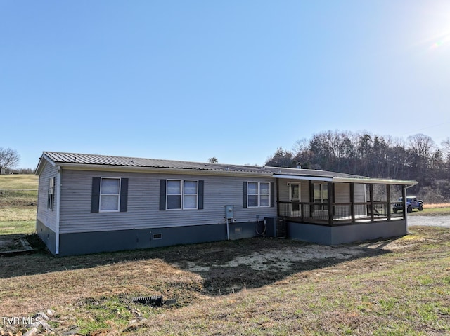 manufactured / mobile home featuring cooling unit, a sunroom, a front lawn, crawl space, and metal roof